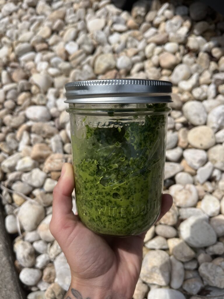 mason jar with kale pesto being held
